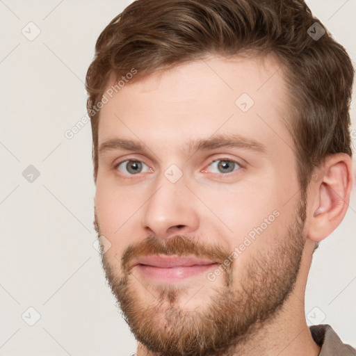 Joyful white young-adult male with short  brown hair and grey eyes