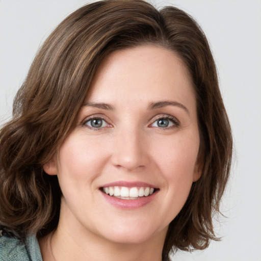 Joyful white young-adult female with medium  brown hair and green eyes