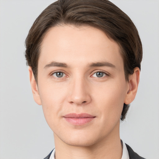 Joyful white young-adult male with short  brown hair and grey eyes