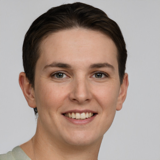 Joyful white young-adult female with short  brown hair and grey eyes