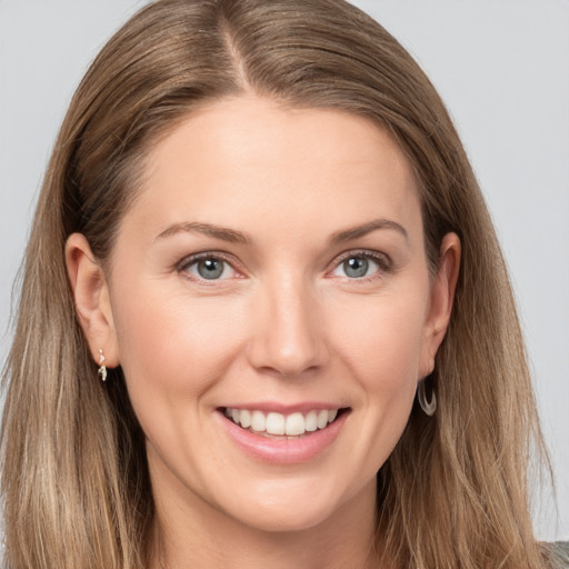 Joyful white young-adult female with long  brown hair and grey eyes