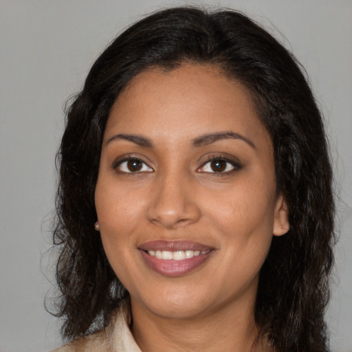 Joyful black young-adult female with long  brown hair and brown eyes
