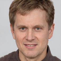 Joyful white adult male with short  brown hair and grey eyes