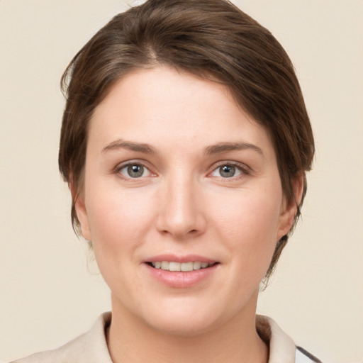 Joyful white young-adult female with medium  brown hair and grey eyes