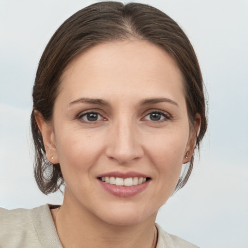 Joyful white young-adult female with medium  brown hair and grey eyes