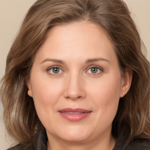 Joyful white adult female with medium  brown hair and grey eyes