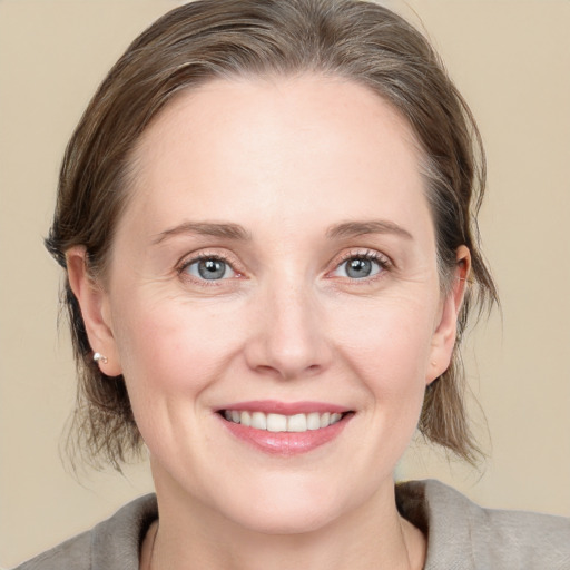 Joyful white young-adult female with medium  brown hair and blue eyes