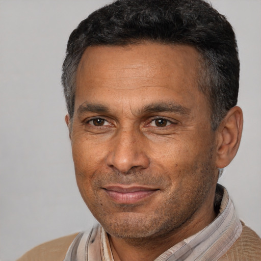 Joyful black adult male with short  brown hair and brown eyes