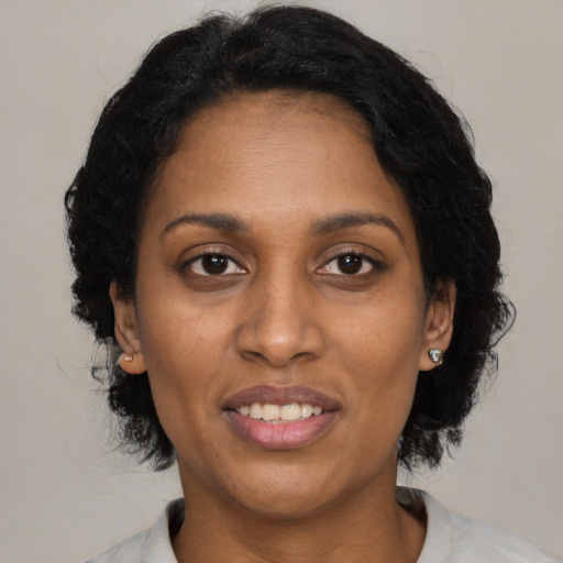 Joyful black young-adult female with medium  black hair and brown eyes