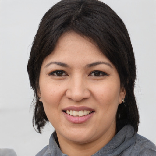 Joyful latino young-adult female with medium  brown hair and brown eyes
