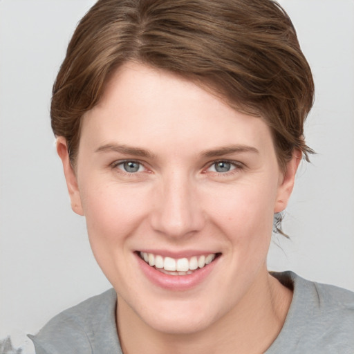 Joyful white young-adult female with short  brown hair and grey eyes