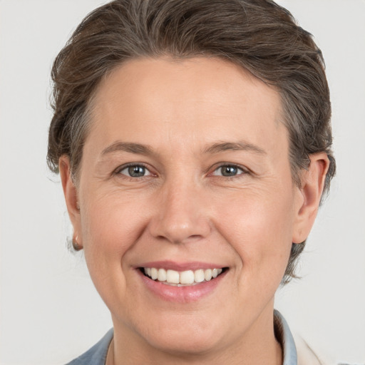 Joyful white adult female with medium  brown hair and grey eyes