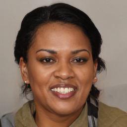 Joyful black adult female with medium  brown hair and brown eyes