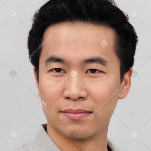 Joyful asian young-adult male with short  black hair and brown eyes