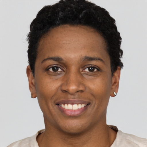 Joyful black young-adult female with short  black hair and brown eyes
