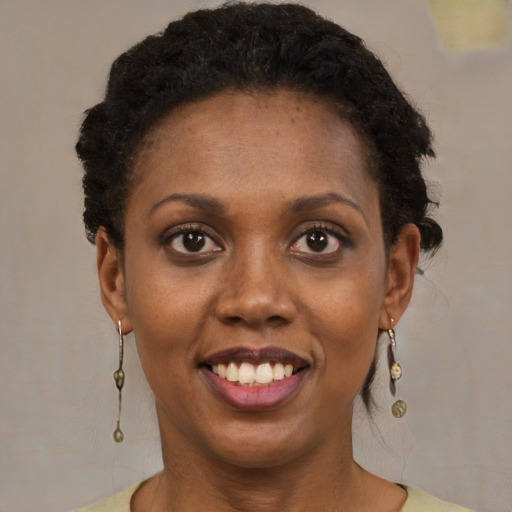 Joyful black young-adult female with short  brown hair and brown eyes