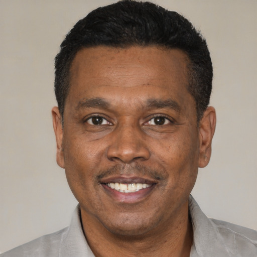 Joyful black adult male with short  black hair and brown eyes