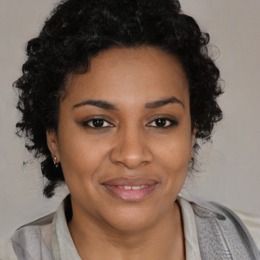 Joyful black young-adult female with medium  brown hair and brown eyes