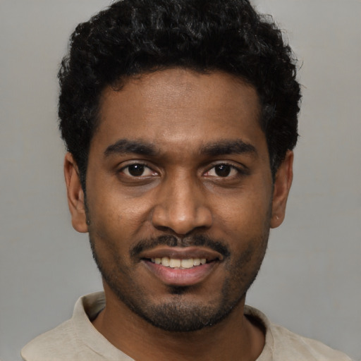 Joyful black young-adult male with short  black hair and brown eyes