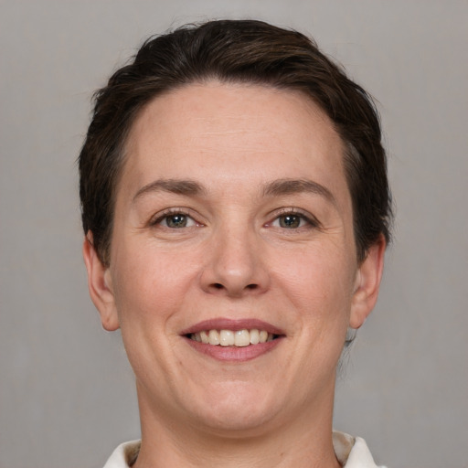 Joyful white adult female with short  brown hair and grey eyes