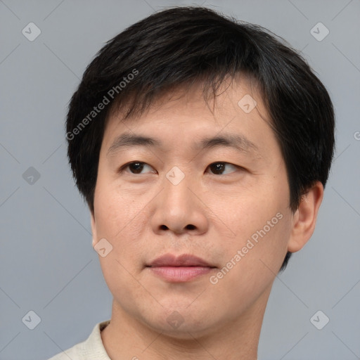 Joyful asian adult male with short  brown hair and brown eyes