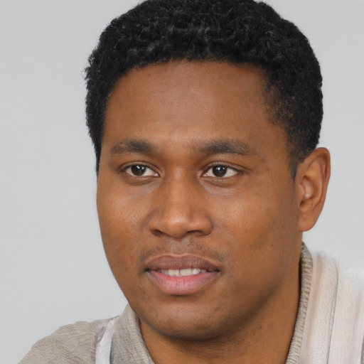 Joyful black young-adult male with short  brown hair and brown eyes