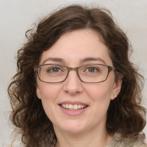 Joyful white adult female with medium  brown hair and green eyes