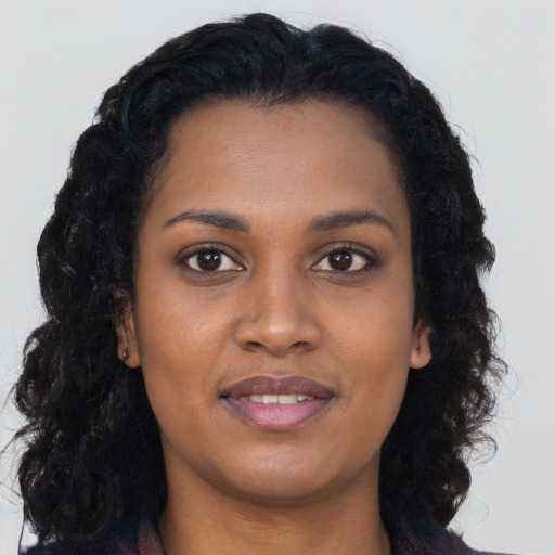 Joyful black young-adult female with long  brown hair and brown eyes