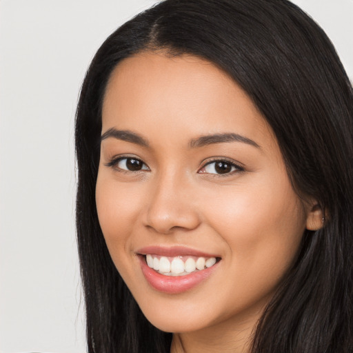 Joyful latino young-adult female with long  black hair and brown eyes