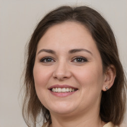 Joyful white young-adult female with medium  brown hair and grey eyes