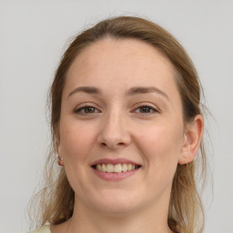 Joyful white young-adult female with medium  brown hair and grey eyes