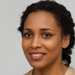 Joyful black young-adult female with long  brown hair and brown eyes