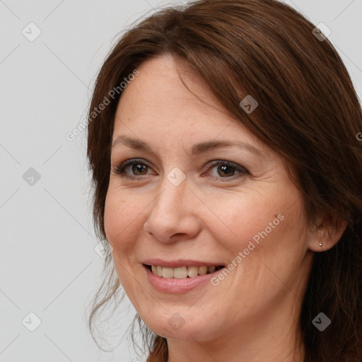 Joyful white adult female with medium  brown hair and brown eyes