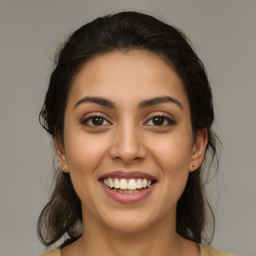 Joyful latino young-adult female with medium  brown hair and brown eyes