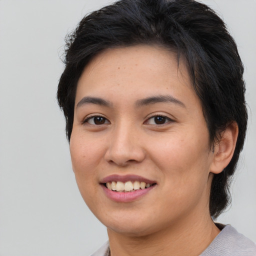 Joyful asian young-adult female with short  brown hair and brown eyes