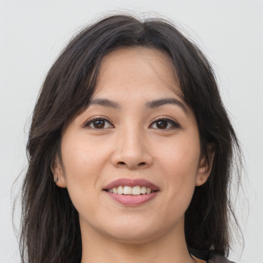 Joyful asian young-adult female with long  brown hair and brown eyes