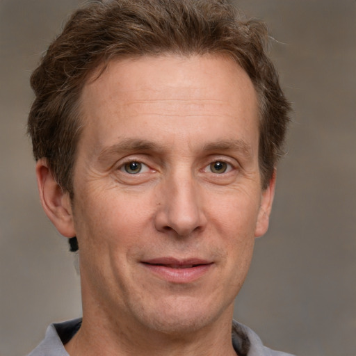 Joyful white adult male with short  brown hair and grey eyes