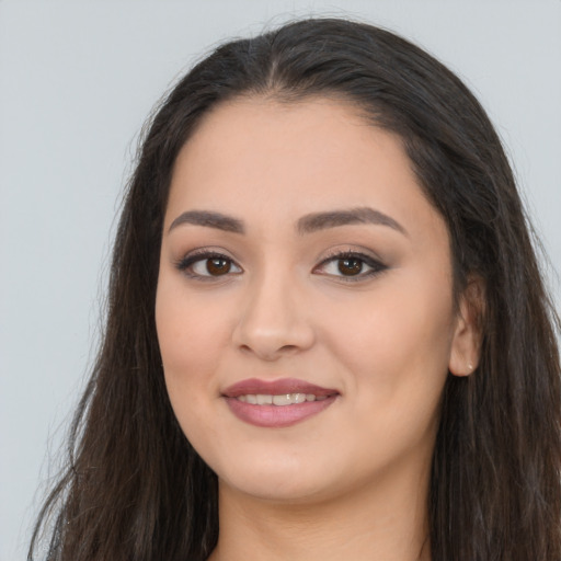 Joyful latino young-adult female with long  brown hair and brown eyes