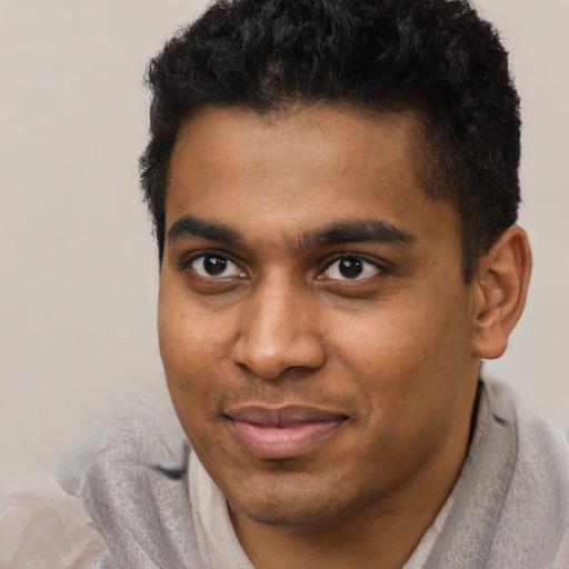 Joyful black young-adult male with short  brown hair and brown eyes