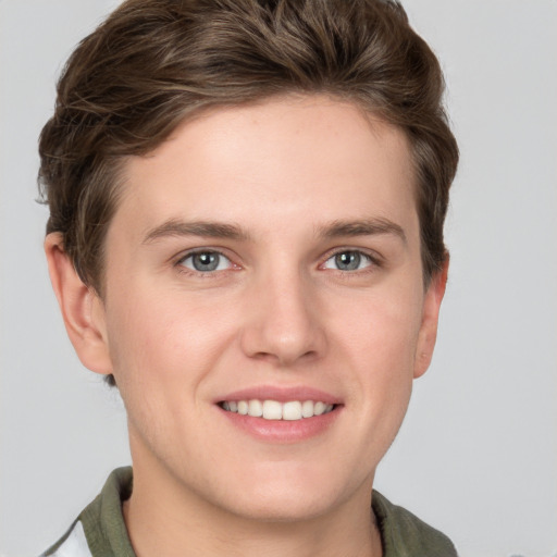 Joyful white young-adult male with short  brown hair and grey eyes