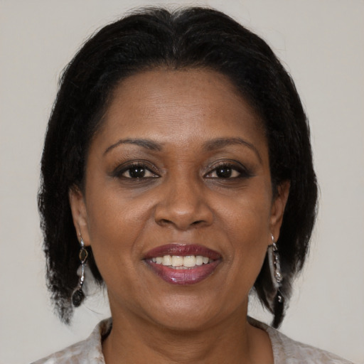 Joyful black adult female with medium  brown hair and brown eyes