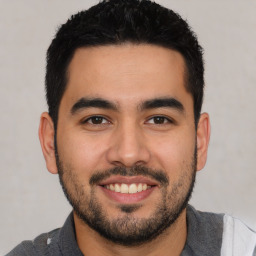 Joyful latino young-adult male with short  black hair and brown eyes