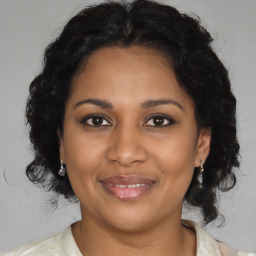 Joyful black adult female with medium  brown hair and brown eyes