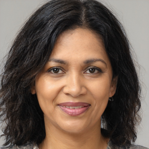 Joyful black adult female with medium  brown hair and brown eyes