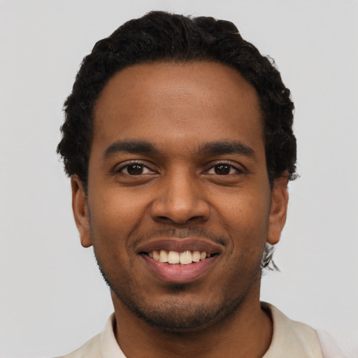 Joyful black young-adult male with short  black hair and brown eyes