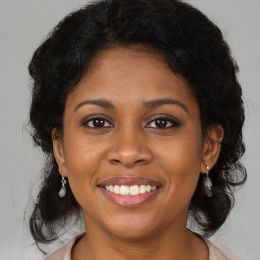 Joyful black young-adult female with medium  brown hair and brown eyes