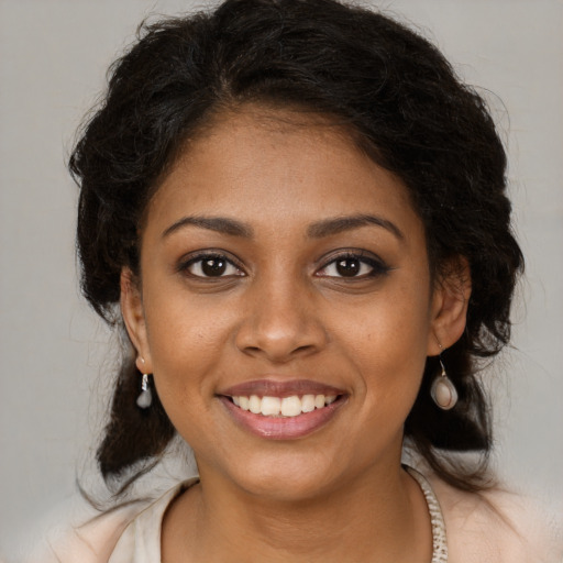 Joyful black young-adult female with medium  brown hair and brown eyes