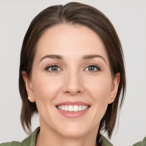 Joyful white young-adult female with medium  brown hair and green eyes