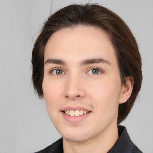 Joyful white young-adult male with medium  brown hair and brown eyes