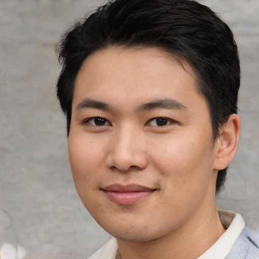 Joyful asian young-adult male with short  brown hair and brown eyes